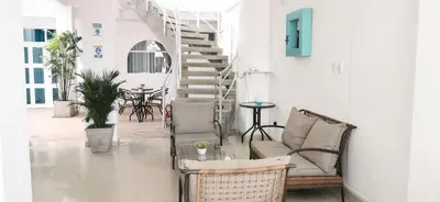 a living room with two chairs and a staircase at AQUAMARINE PARACAS Beach Hostal in Paracas