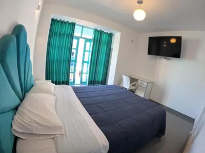 a bedroom with a blue bed and a television at AQUAMARINE PARACAS Beach Hostal in Paracas