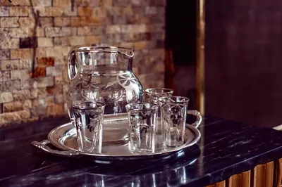 a tray with glasses on a table with a glass pitcher at Ana Frank Boutique Hotel in Lima