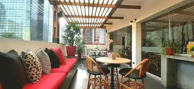 a restaurant with a red couch and a table and chairs at Ana Frank Boutique Hotel in Lima