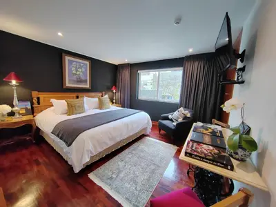 a hotel room with a large bed and a chair at Ana Frank Boutique Hotel in Lima