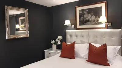 a bedroom with a bed with two mirrors on the wall at Ana Frank Boutique Hotel in Lima
