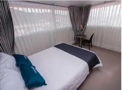 a bedroom with a bed and a table with a chair at Hotel Luna de Oro Cusco in Cusco