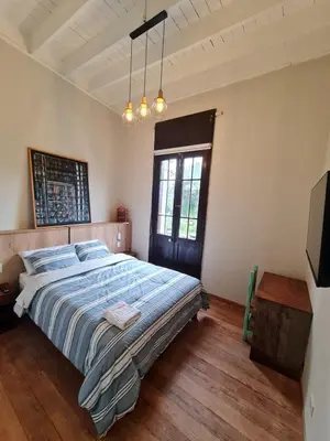 a bedroom with a bed with a blue comforter and a window at Flying Dog Lima B&B in Lima