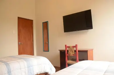 a bedroom with a bed and a tv on the wall at Flying Dog Lima B&B in Lima
