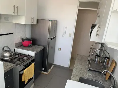 a small kitchen with a stove and a refrigerator at Peruvian Apartment in Lima
