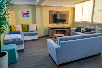 a living room with two couches and a tv at El Paraíso Eco Resort in Pisco