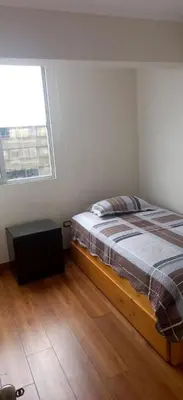 a bedroom with a bed in a room with a window at Miraflores Heart Apartment in Lima