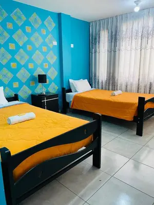 two beds in a room with blue walls at Sunset Hostel Airport in Lima