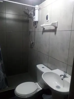 a bathroom with a shower and a toilet and a sink at Sunset Hostel Airport in Lima