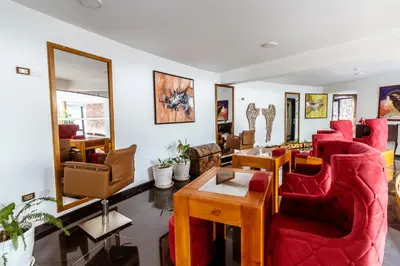 a living room with red chairs and a table at Hacienda del Valle Sagrado in Urubamba