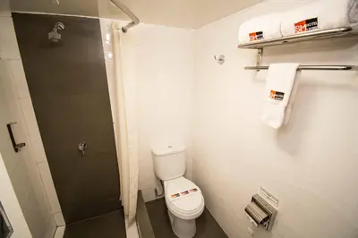 a small bathroom with a toilet and a shower at SM Hotel in Lima