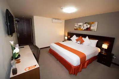 a hotel room with a large bed and a desk at SM Hotel in Lima