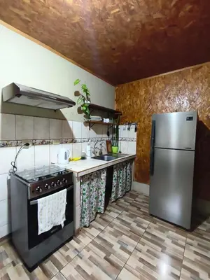 a kitchen with a stainless steel refrigerator and counters at Hospedaje Cattleya in Oxapampa