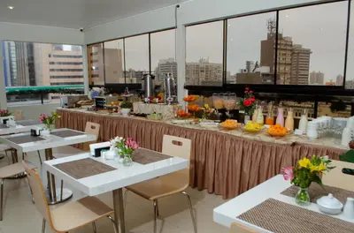 a restaurant with tables with flowers on it at Hotel María Luisa in Lima