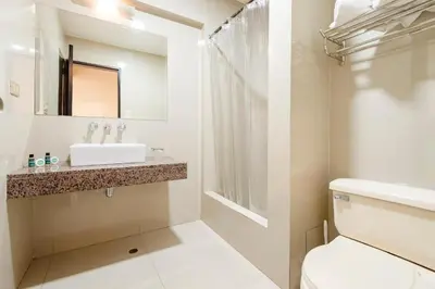 a white bathroom with a sink and a toilet at Hotel María Luisa in Lima
