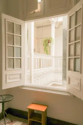 a window in a room with a table and a stool at 1900 Backpacker's Hostel in Lima