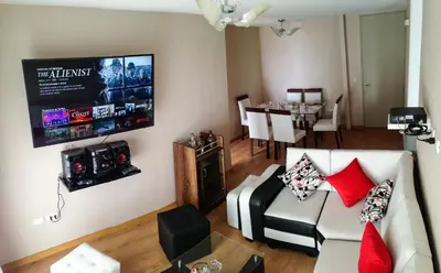 a living room with a couch and a tv on the wall at Condominio Uptown de 2 dormitorios in Lima