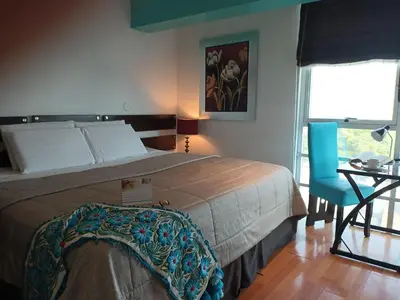 a bedroom with a bed and a table and a chair at Hotel Vila Santa in Lima