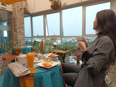 a woman sitting at a table with a plate of food at Hotel Vila Santa in Lima