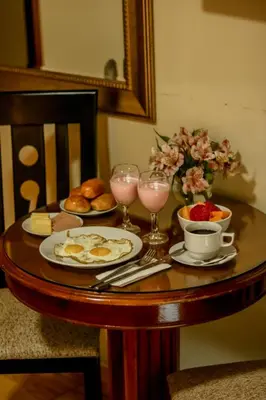 a table with plates of food and glasses of wine at Epiqus Hotel in Lima