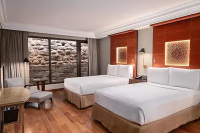 a hotel room with two beds and a desk at JW Marriott El Convento Cusco in Cusco