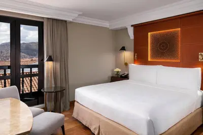 a hotel room with a bed and a table and a window at JW Marriott El Convento Cusco in Cusco