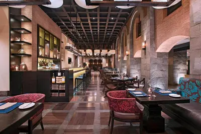 a restaurant with tables and chairs and a bar at JW Marriott El Convento Cusco in Cusco