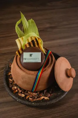 a cake in a wooden bowl with a toothpick in it at JW Marriott El Convento Cusco in Cusco