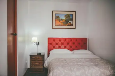 a bed with a red headboard in a bedroom at Hotel Excalibur in Lima