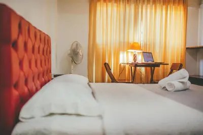 a bedroom with a bed and a desk with a laptop at Hotel Excalibur in Lima