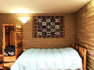 a bedroom with a bed and a wall with a picture at Alojamiento Casa Yanantin de Maravilca in Concepción