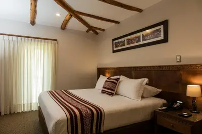 a bedroom with a large bed and a telephone at Del Pilar Ollantaytambo in Ollantaytambo