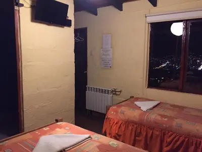 a room with two beds and a window at Samay Wasi Hostel in Cusco