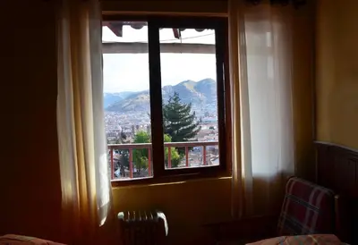 a window with a view of a city at Samay Wasi Hostel in Cusco