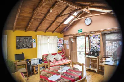 a living room with a couch and a clock on the wall at Samay Wasi Hostel in Cusco
