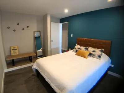 a bedroom with a large bed with a blue wall at MLA apartments - 28 de Julio in Lima