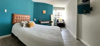 a bedroom with a large bed with blue walls at MLA apartments - 28 de Julio in Lima