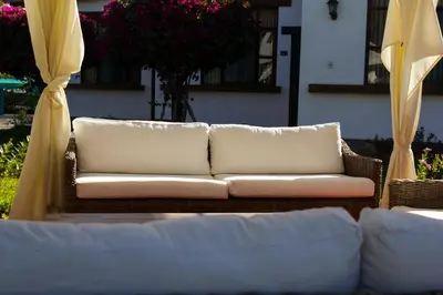 a white couch sitting on a patio with yellow curtains at Casa Hacienda Nasca Oasis in Nazca
