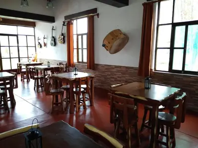 a restaurant with wooden tables and chairs and windows at Casa Hacienda Nasca Oasis in Nazca