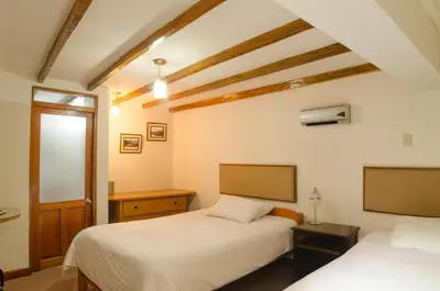 a bedroom with two beds and a window at Los Aticos B&B with Coworking in Cusco