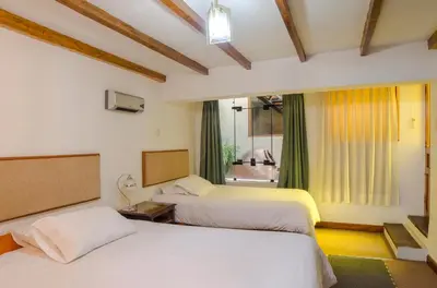 a bedroom with two beds and a window at Los Aticos B&B with Coworking in Cusco