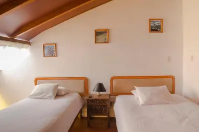 two beds sitting next to each other in a bedroom at Los Aticos B&B with Coworking in Cusco