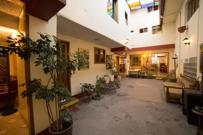 a large hallway with potted plants in a building at Los Aticos B&B with Coworking in Cusco