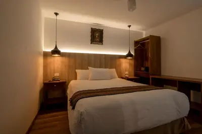 a bedroom with a large bed and two lights at Hotel Rojas Inn in Cusco