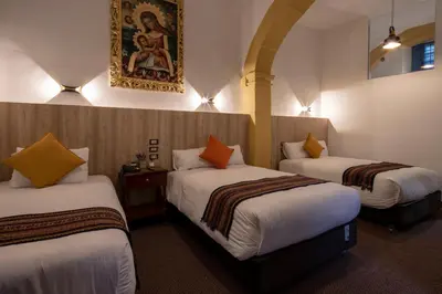 a hotel room with two beds and a painting on the wall at Hotel Rojas Inn in Cusco