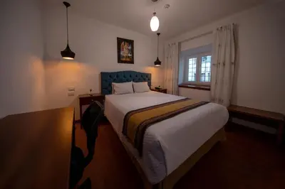 a bedroom with a bed and a table and a window at Hotel Rojas Inn in Cusco