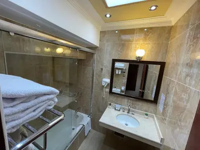 a bathroom with a sink and a tub and a mirror at Hotel Rojas Inn in Cusco