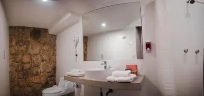a bathroom with a sink and a toilet and a mirror at Nao Victoria Hostel in Cusco