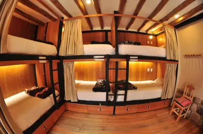 a room with four bunk beds on a boat at Nao Victoria Hostel in Cusco
